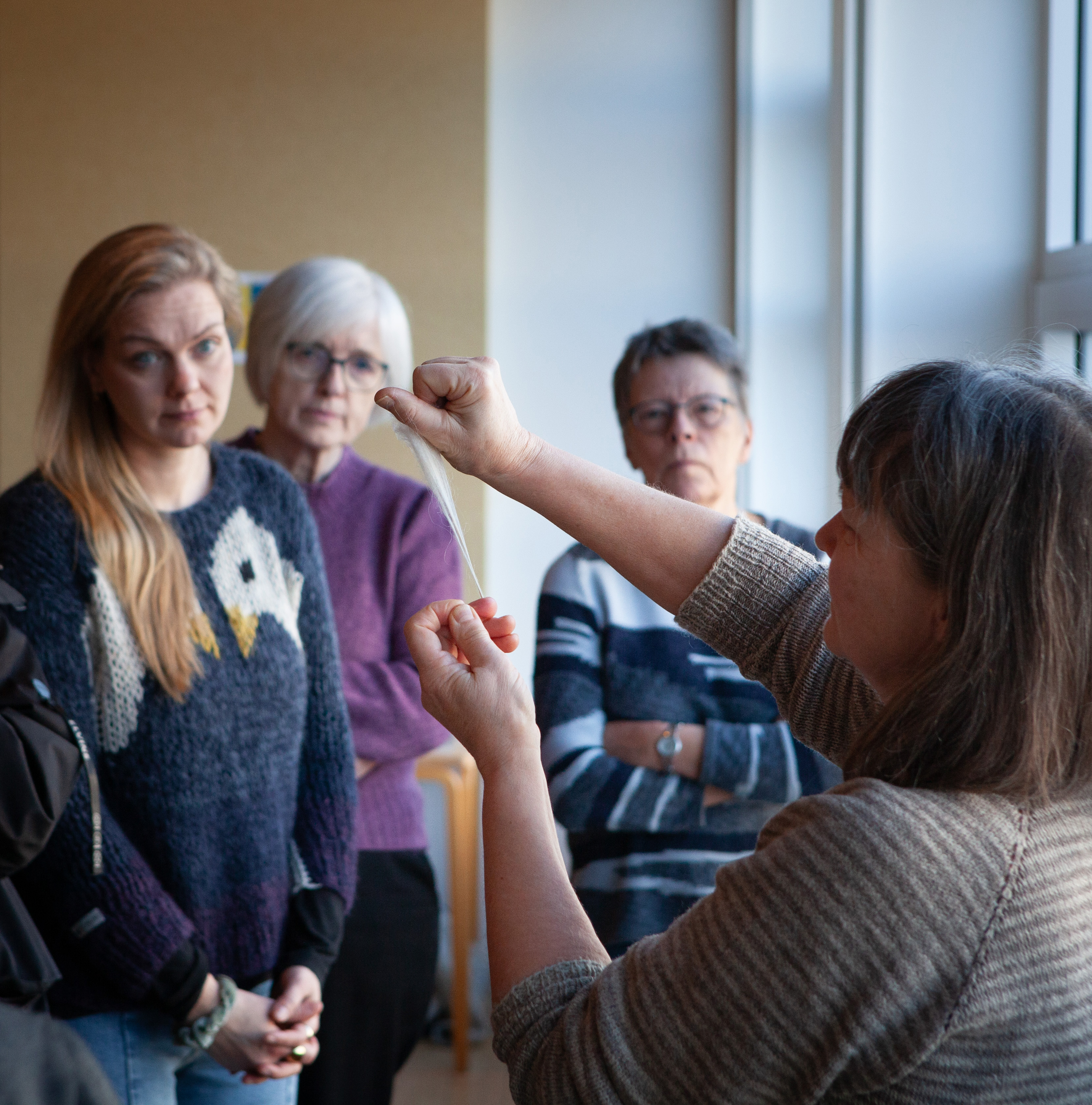 Woman holds in white wool.