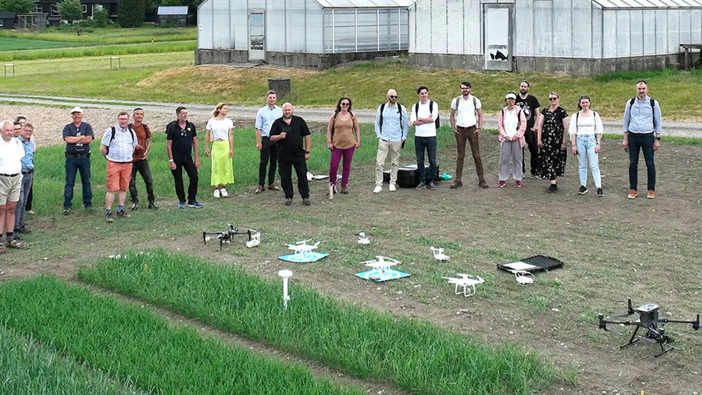 A group of people standing beside several drones on the ground.