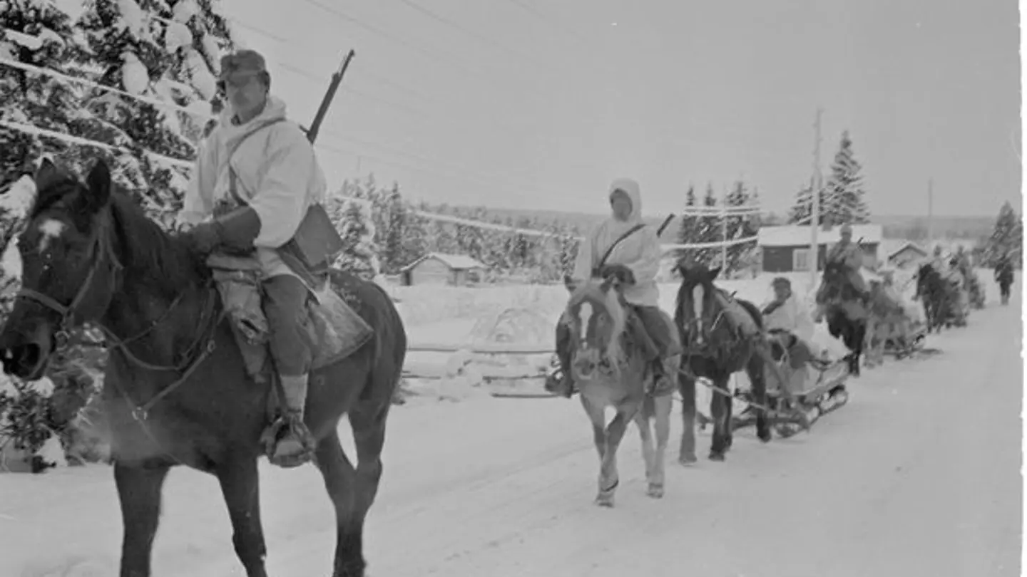 Mustavalkoinen kuva: sotilaita hevosen selässä.