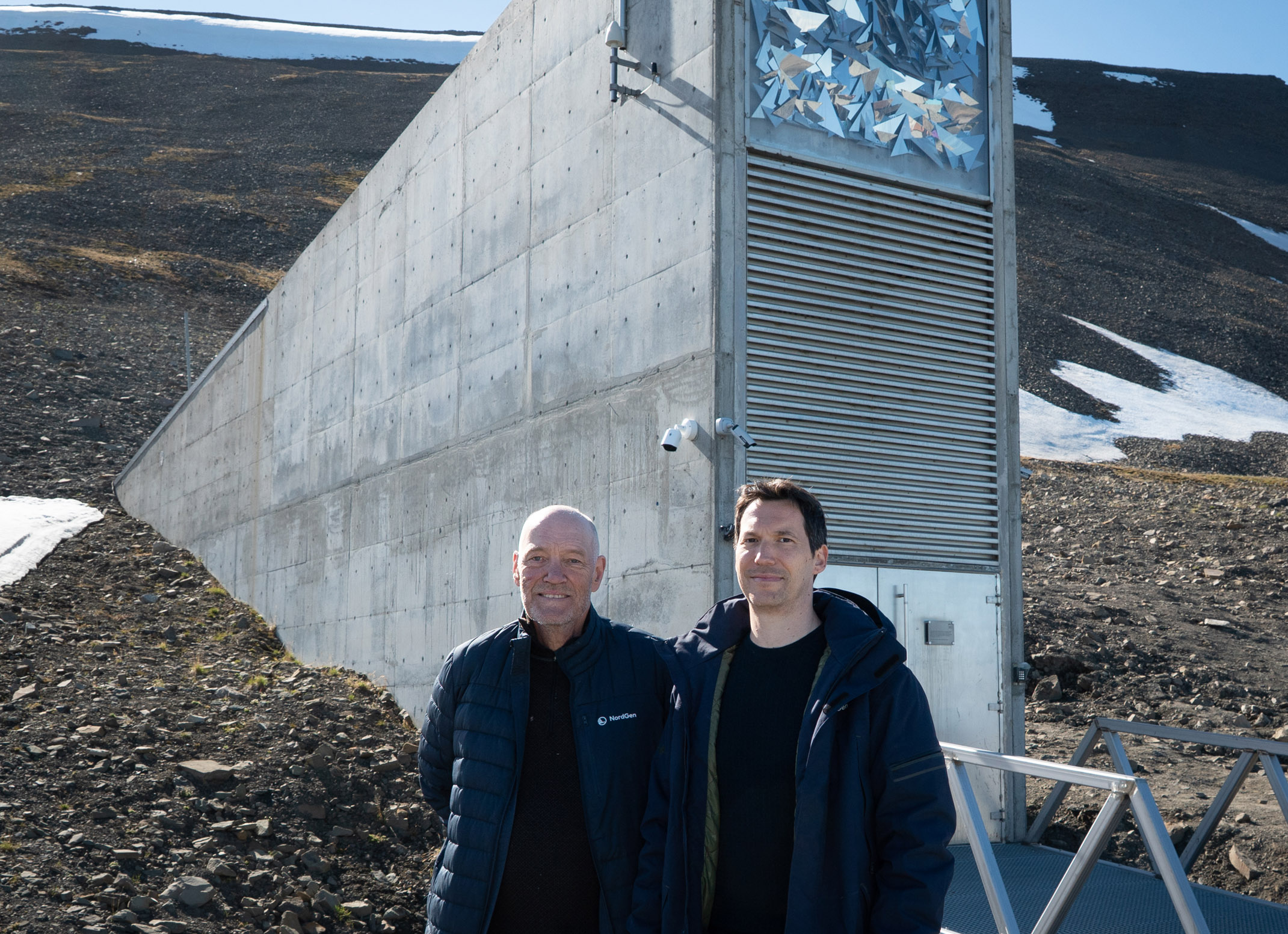 Two men infront of a building.
