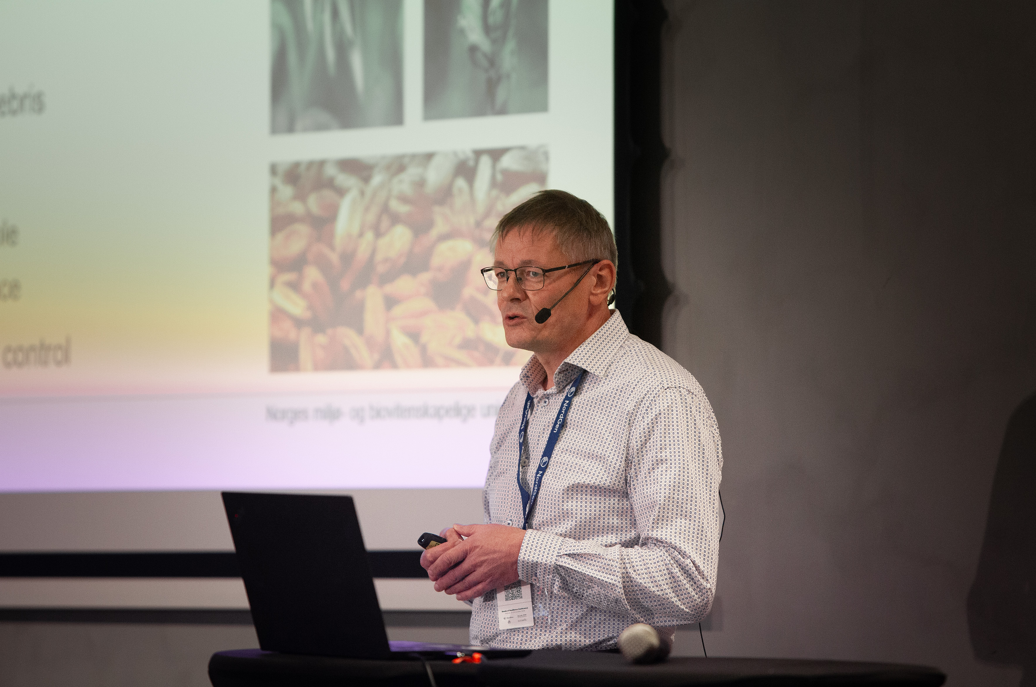 Man in white shirt giving presentation on stage