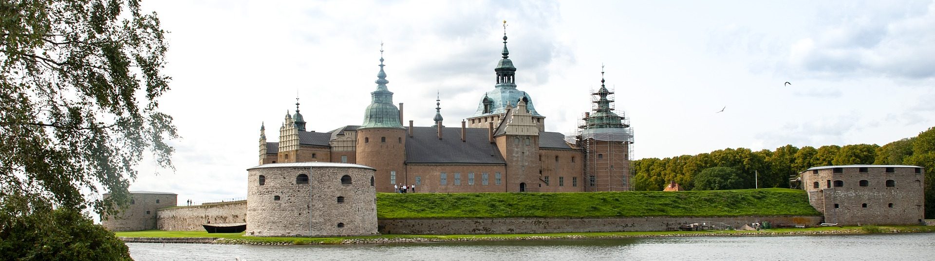 Bild på Kalmar slott med vatten i förgrunden.