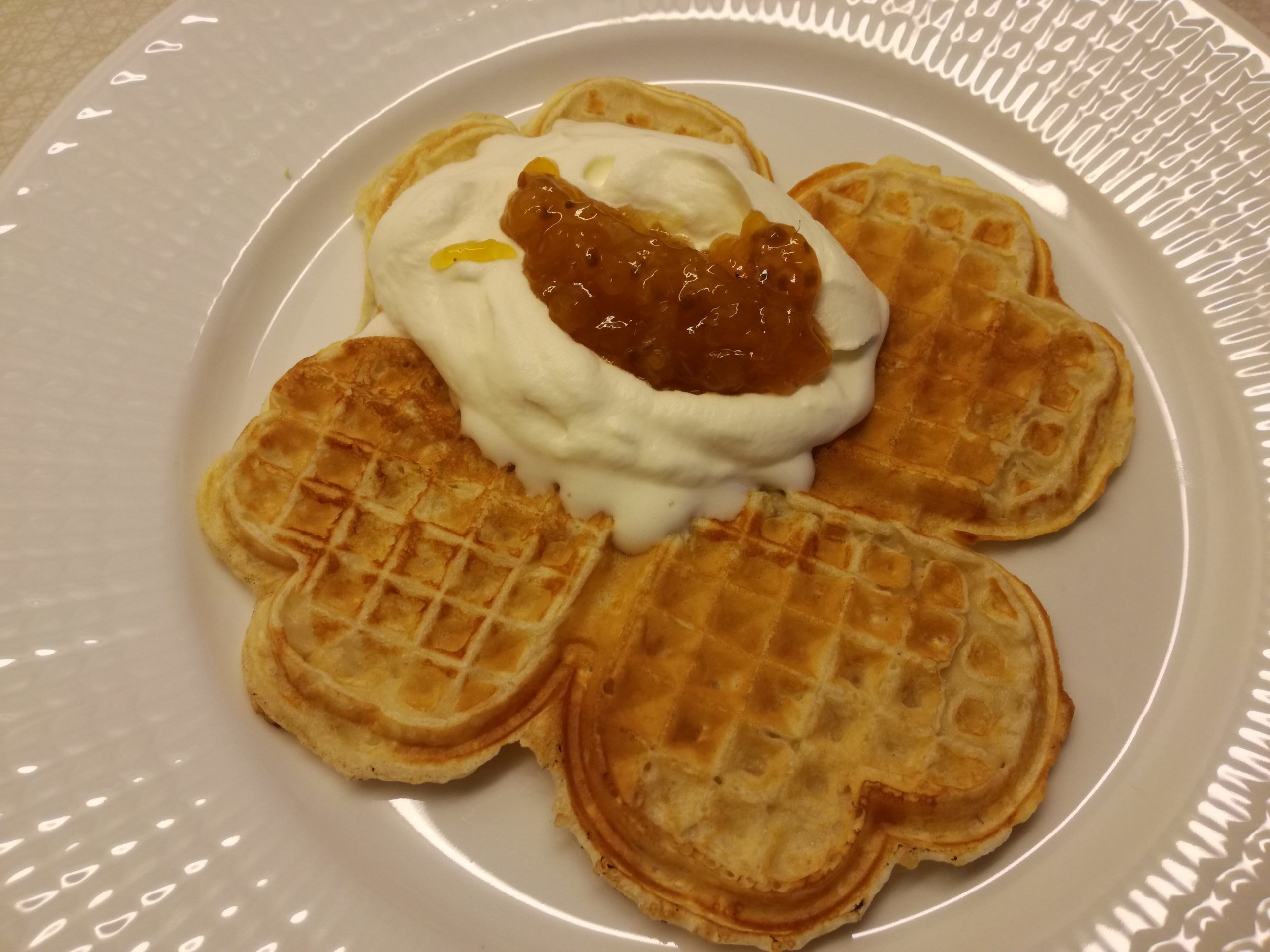 Waffle served with cream and cloudberries