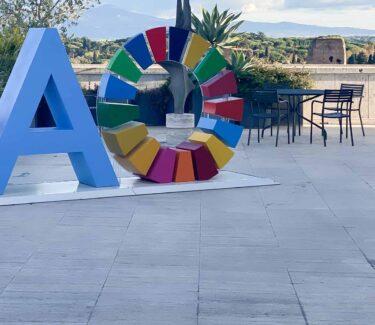 Sculpture of the letters FAO with the O as the ring of the SDG-goals. Roman background.